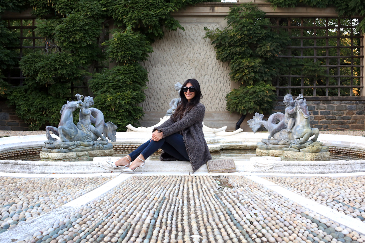 dumbarton-oaks-pebble-garden-fountain-iro-jacket-sitting-smiling